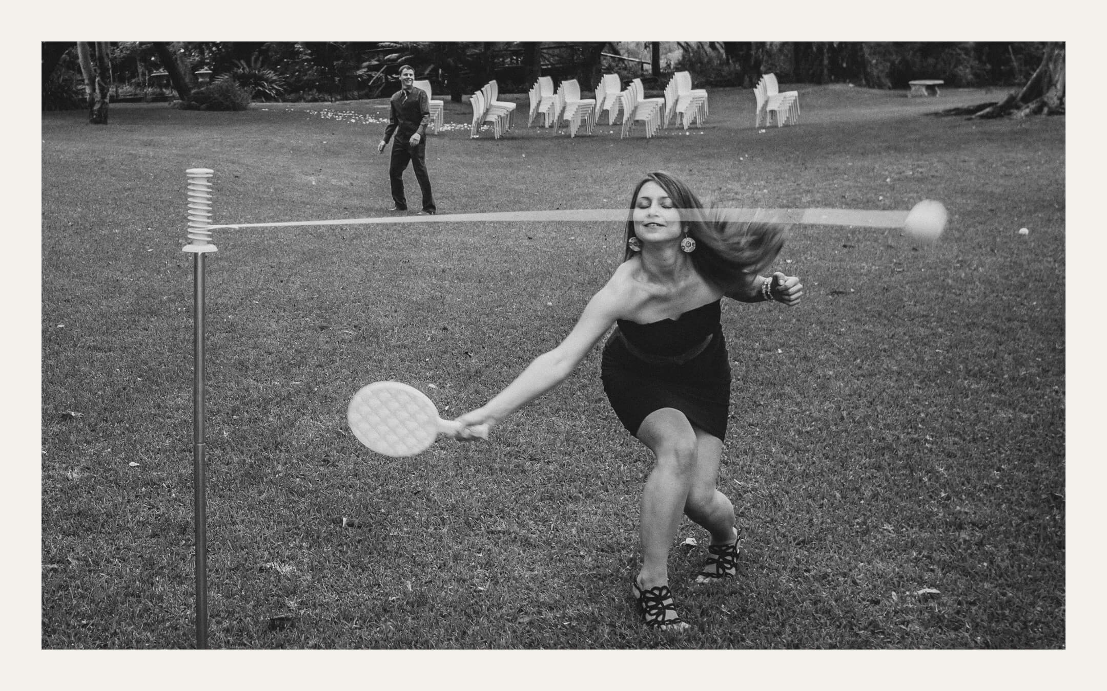 Guest playing swingball on a lawn as chairs are set out for the ceremony. Ben Viljoen Photography